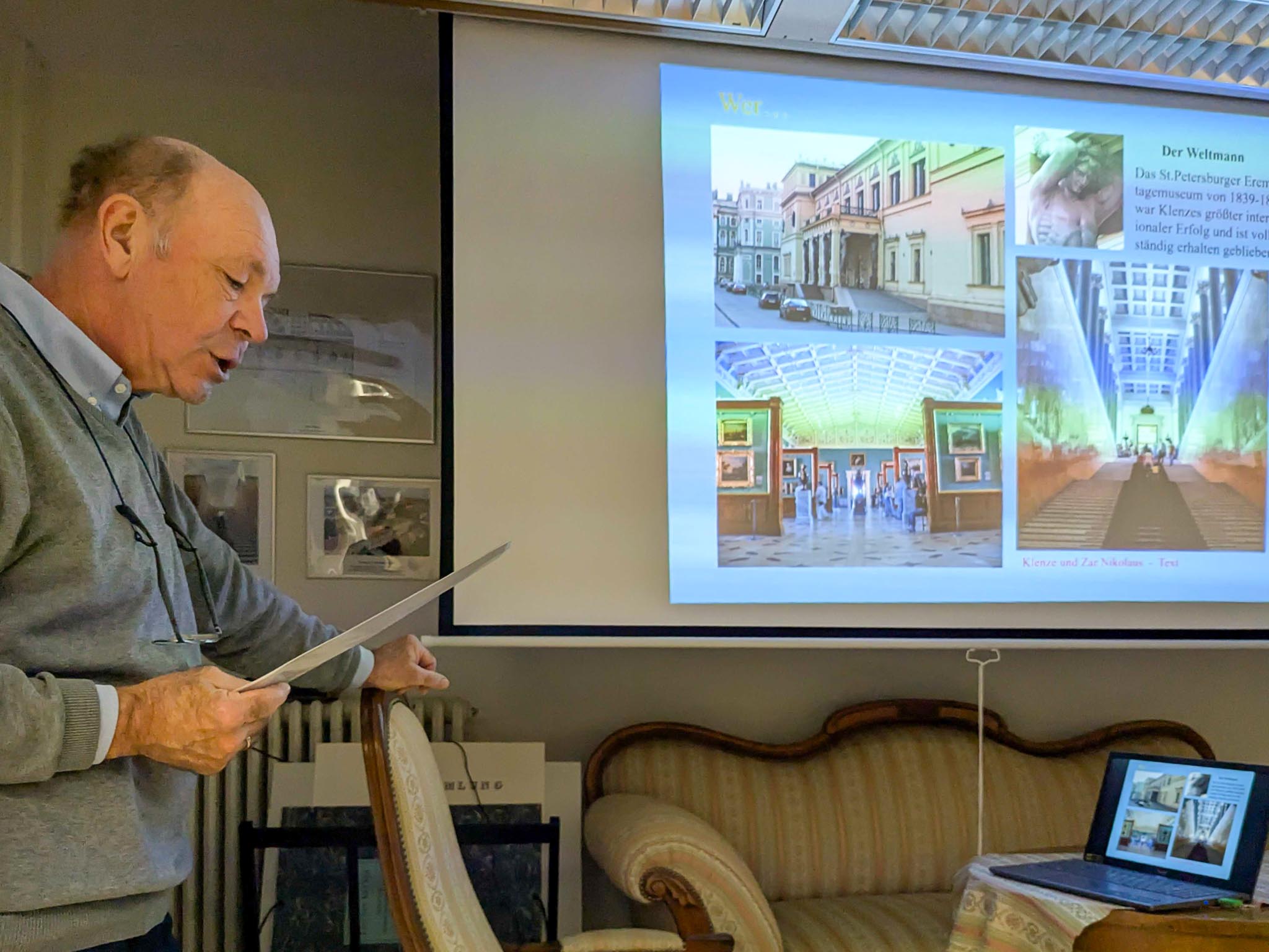 Referent erläutert bei einem Vortrag im Klenze-Haus eine Präsentation zur Eremitage in St. Petersburg, dem Werk des Architekten Leo von Klenze.