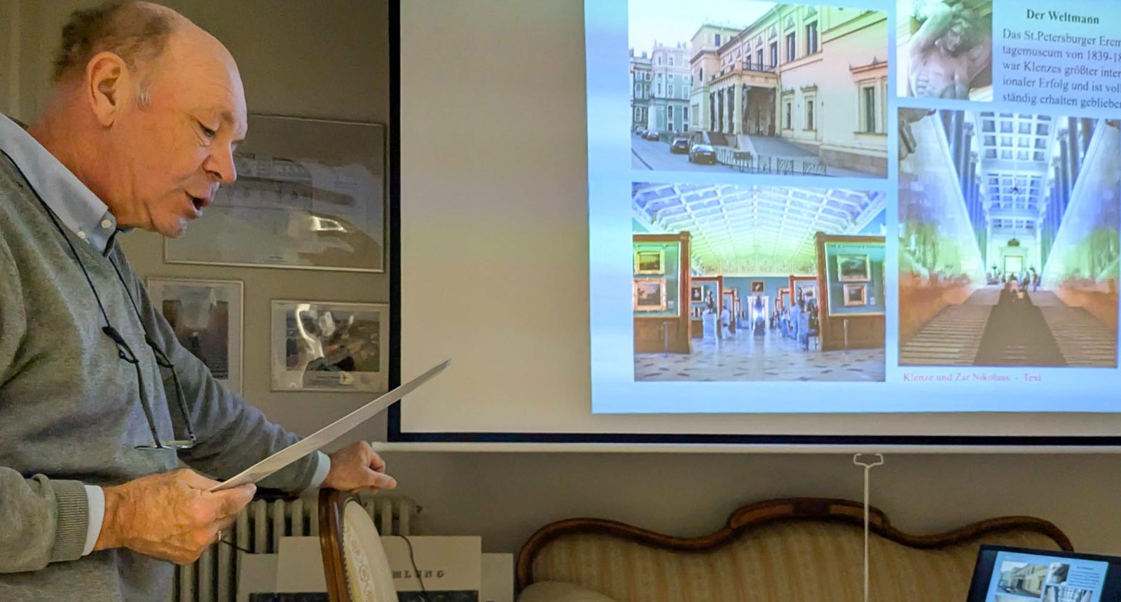 Referent erläutert bei einem Vortrag im Klenze-Haus eine Präsentation zur Eremitage in St. Petersburg, dem Werk des Architekten Leo von Klenze.